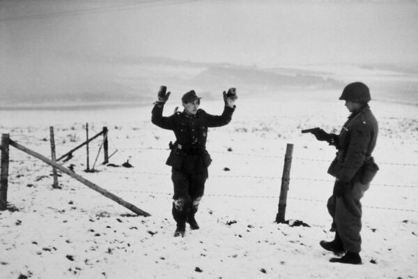 Un soldato americano con un prigioniero tedesco durante la battaglia delle Ardenne. Bastogne, Belgio